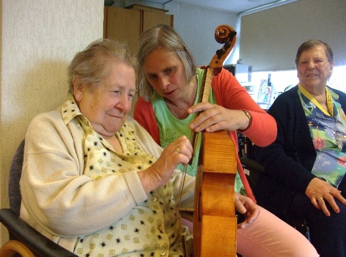 foto, mevrouw van Kooten tokkelt op de viola da gamba